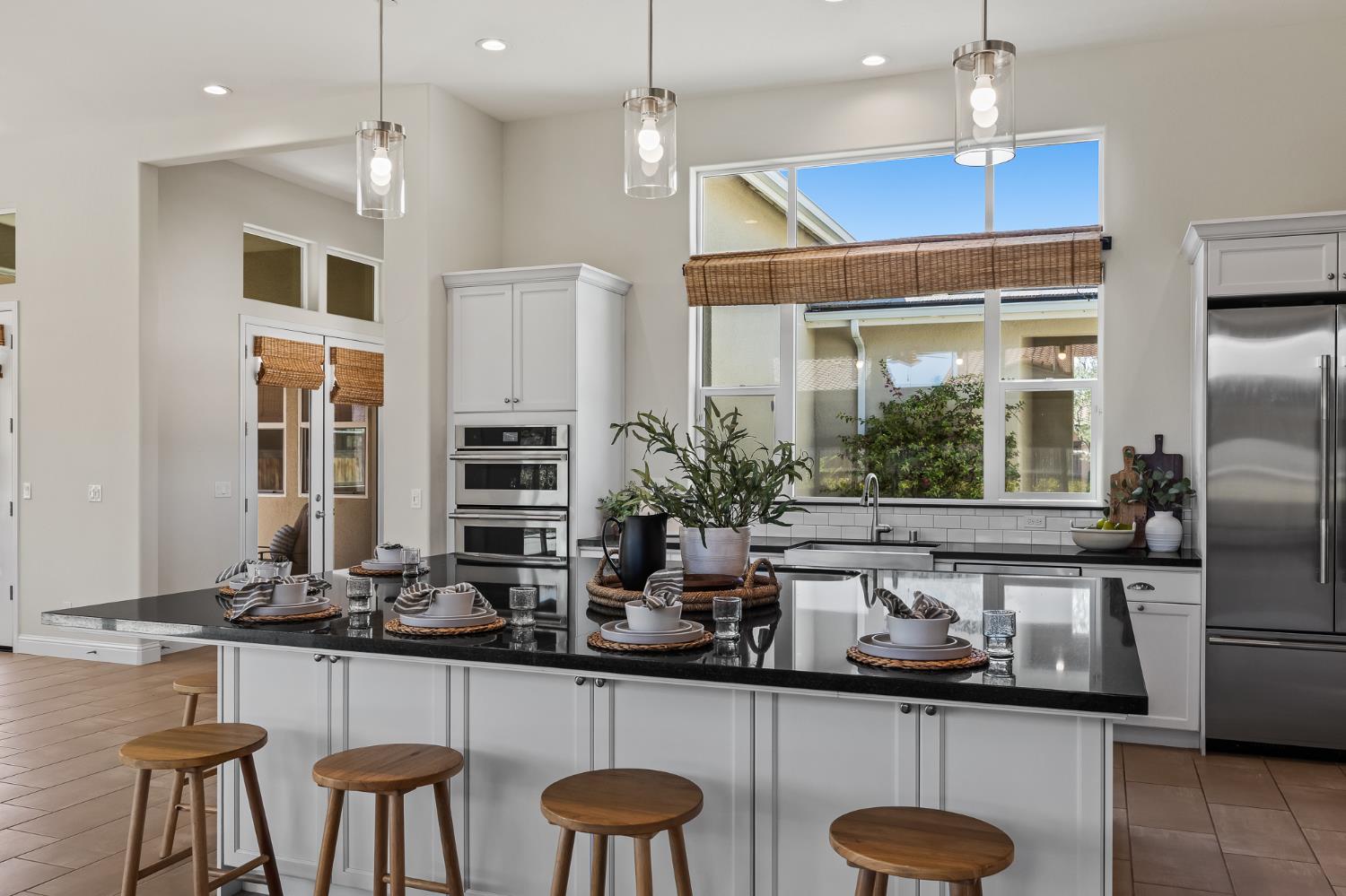 998 Highland Road West Madera, CA 93636 - Photo 13 of 61 a kitchen with stainless steel appliances kitchen island granite countertop a table chairs in it and wooden floors