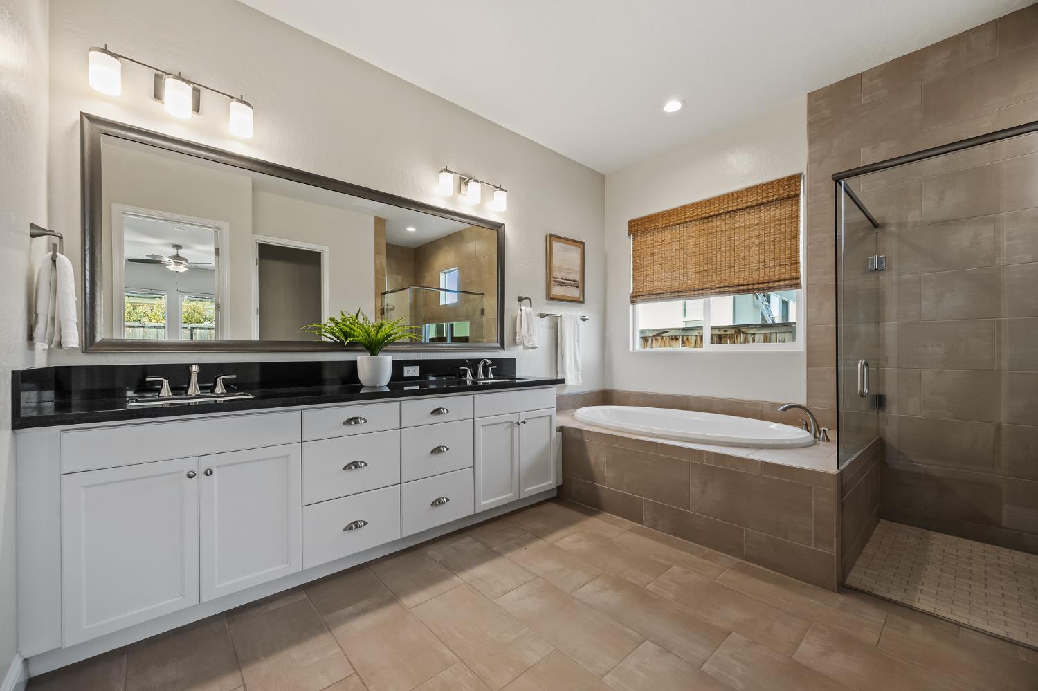 998 Highland Road West Madera, CA 93636 - Photo 53 of 61 a spacious bathroom with double vanity a mirror a bathtub and a shower