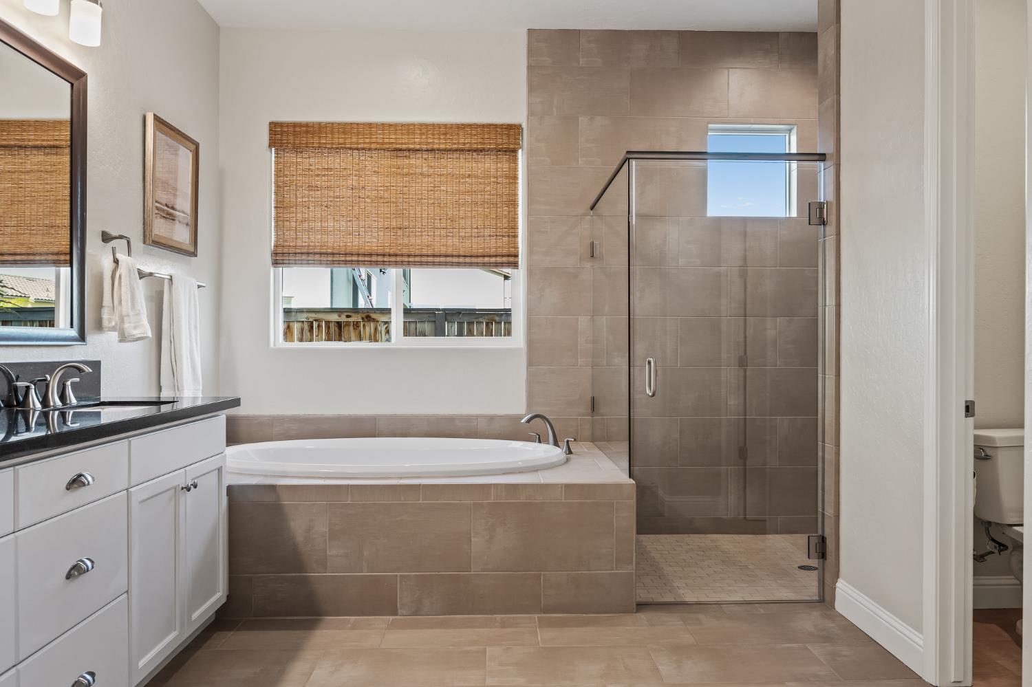 998 Highland Road West Madera, CA 93636 - Photo 54 of 61 a bathroom with a bathtub a shower a sink and a window