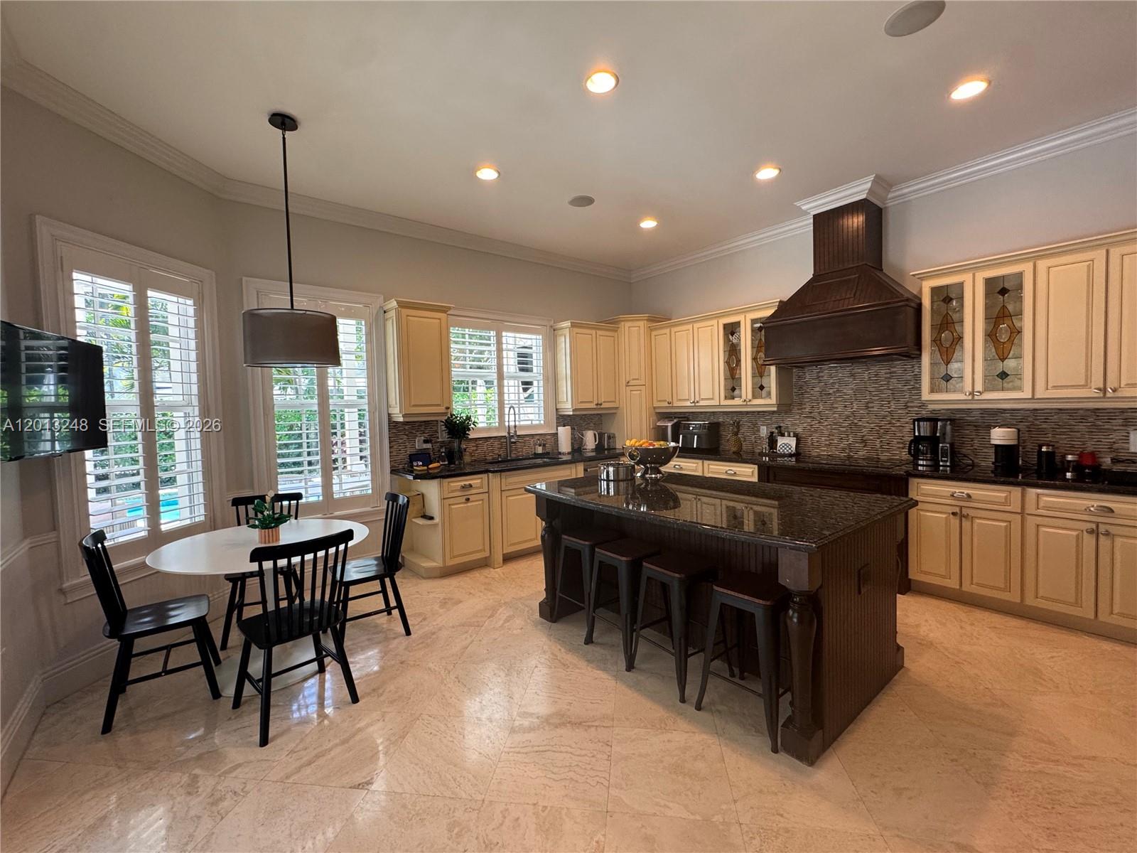 5000 Southwest 73rd Terrace Miami, FL 33143 - Photo 9 of 24 a kitchen with granite countertop a stove a sink a dining table and chairs