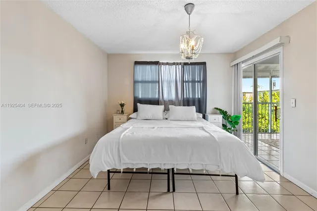 a spacious bedroom with a bed and a chandelier