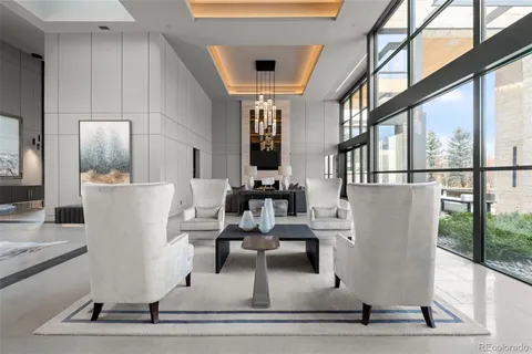 a living room with furniture a fireplace and potted plants with wooden floor