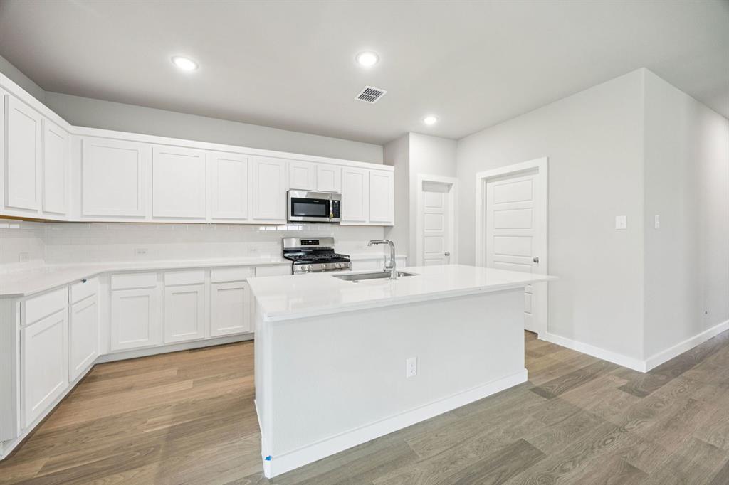 657 Poppy Lane Lavon, TX 75166 - Photo 8 of 28 a kitchen with kitchen island a sink stainless steel appliances and cabinets