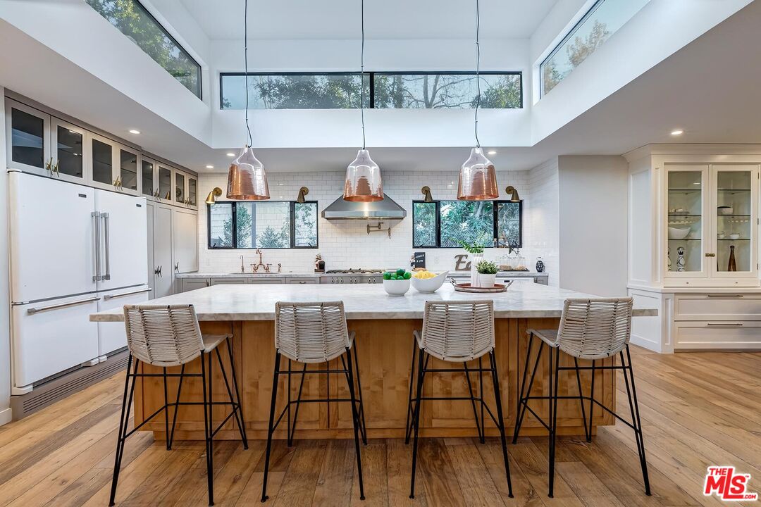 5401 Ostrom Avenue Encino, CA 91316 - Photo 14 of 73 a kitchen with a table chairs stove and cabinets