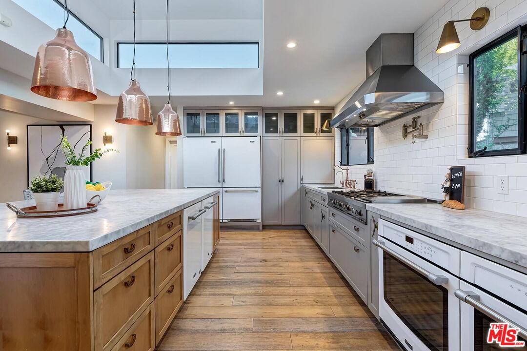 5401 Ostrom Avenue Encino, CA 91316 - Photo 17 of 73 a kitchen with stainless steel appliances granite countertop a lot of counter space and a sink