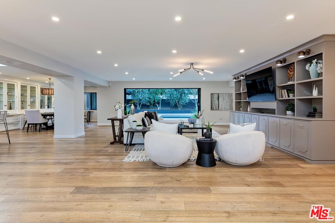 5401 Ostrom Avenue Encino, CA 91316 - Photo 3 of 73 a living room with couches and kitchen view with wooden floor