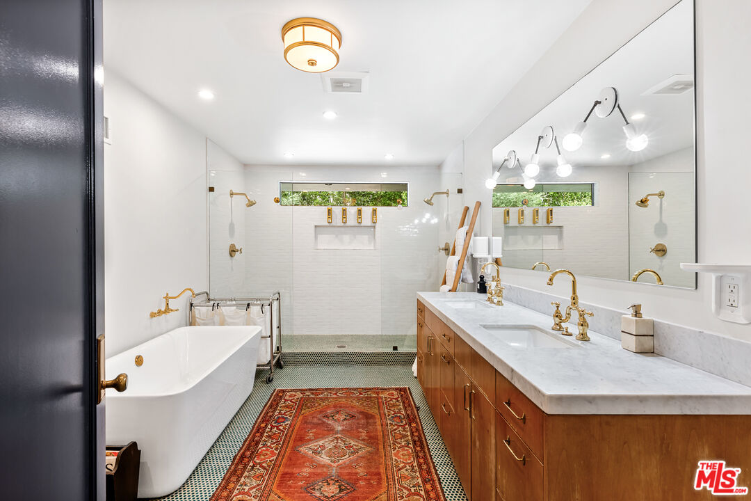 5401 Ostrom Avenue Encino, CA 91316 - Photo 33 of 73 a bathroom with a sink a large mirror and a bathtub