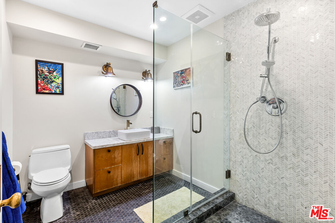 5401 Ostrom Avenue Encino, CA 91316 - Photo 39 of 73 a bathroom with a toilet sink vanity granite and mirror