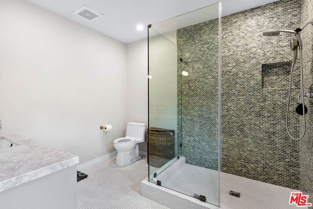 5401 Ostrom Avenue Encino, CA 91316 - Photo 45 of 73 a bathroom with a granite countertop sink a toilet and shower