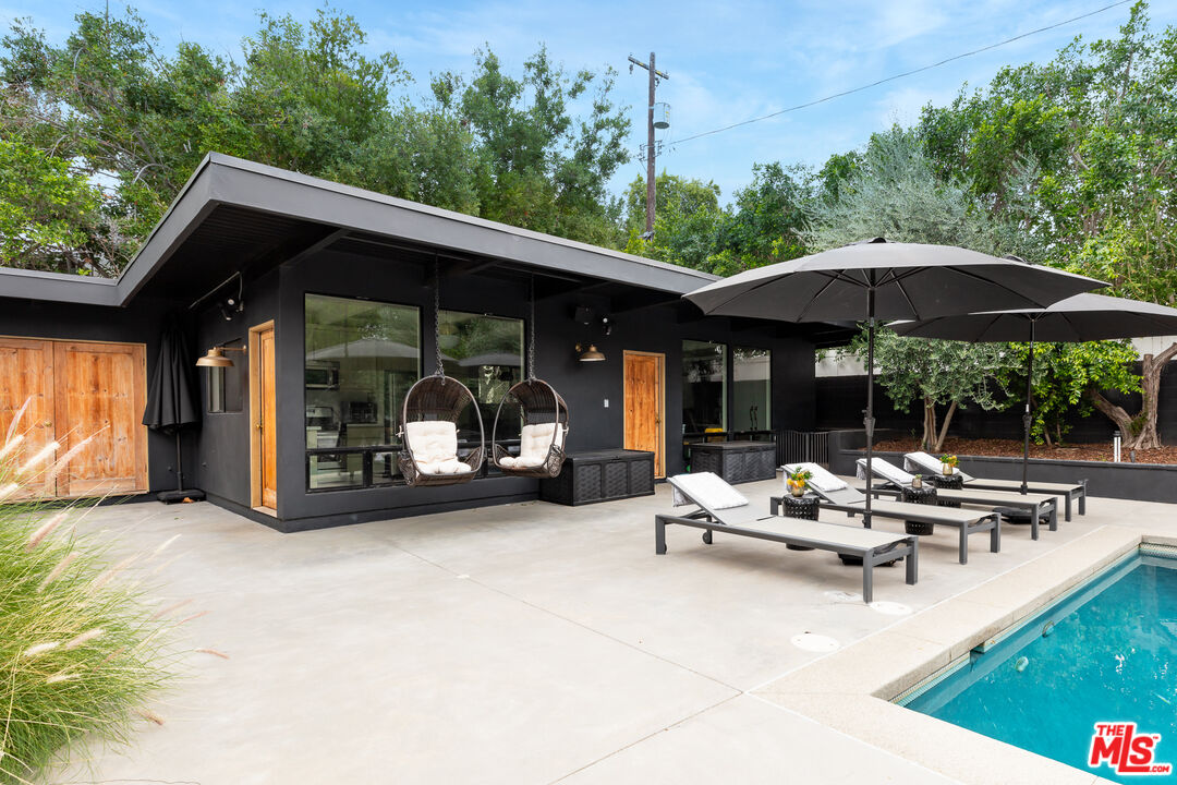 5401 Ostrom Avenue Encino, CA 91316 - Photo 49 of 73 a view of a patio with table and chairs under an umbrella