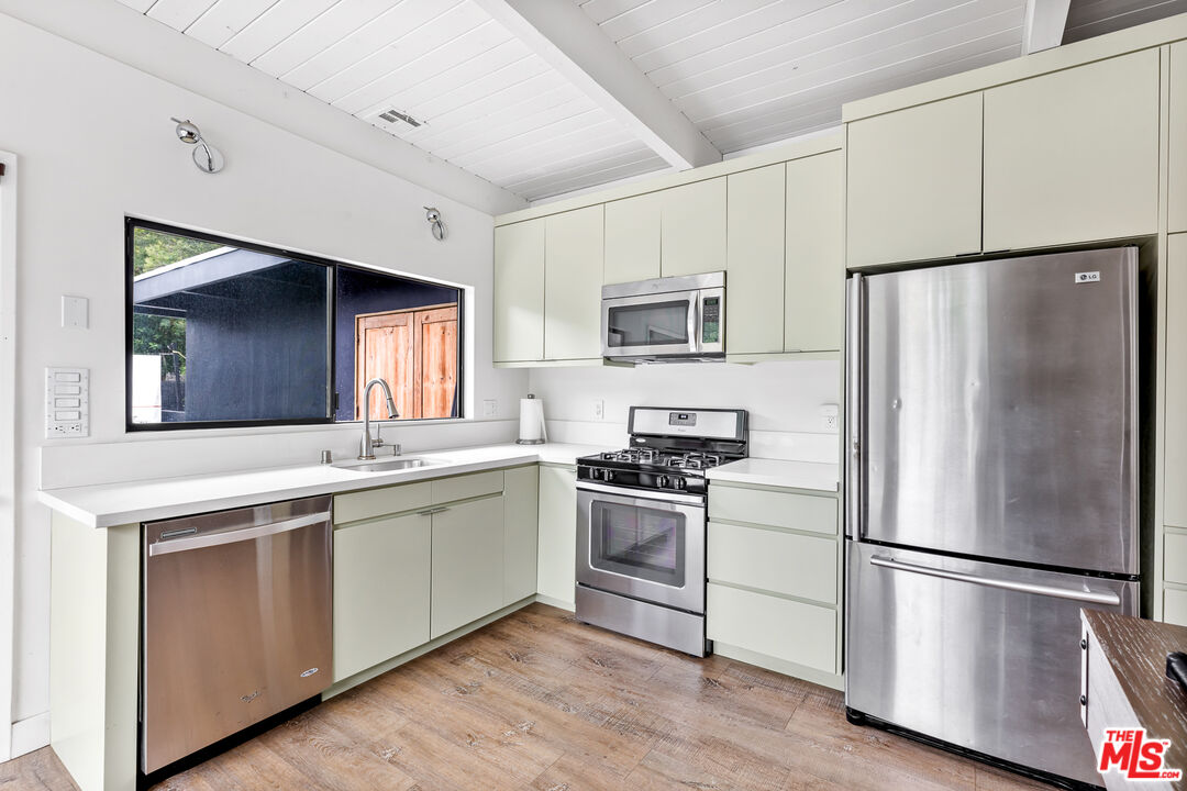 5401 Ostrom Avenue Encino, CA 91316 - Photo 51 of 73 a kitchen with cabinets stainless steel appliances a sink and a window