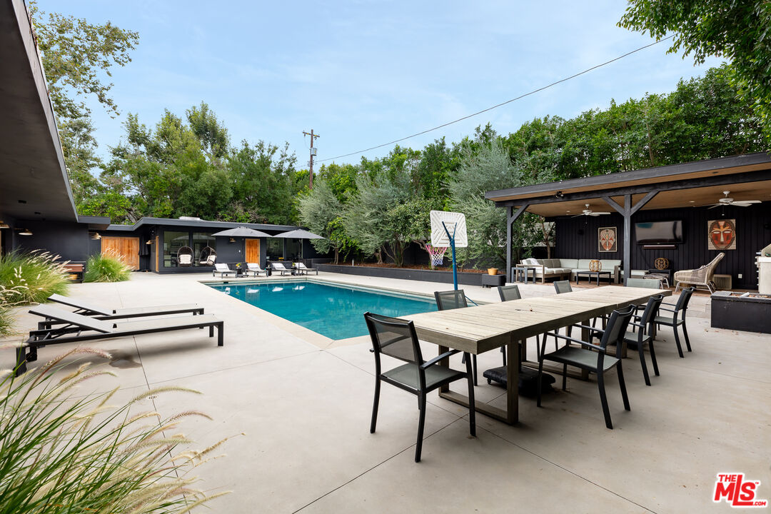 5401 Ostrom Avenue Encino, CA 91316 - Photo 64 of 73 a view of a patio with table and chairs and potted plants with wooden floor and fence
