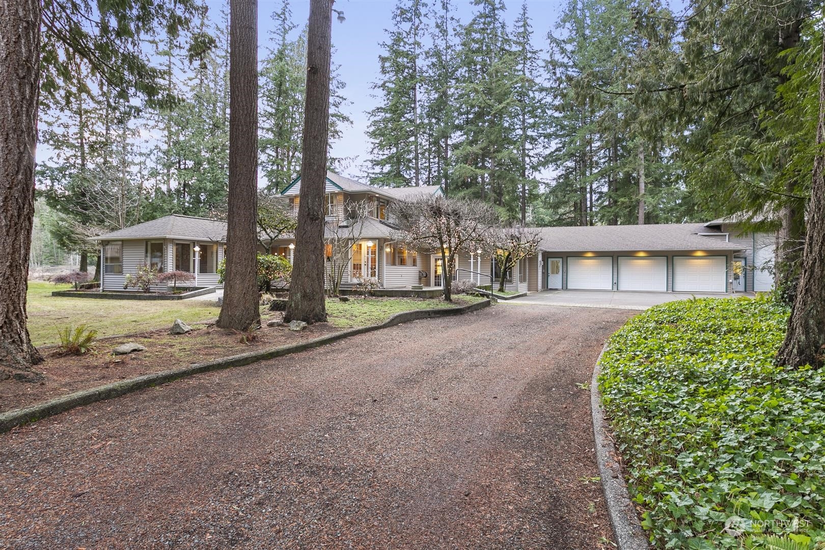 a front view of a house with a garden and trees