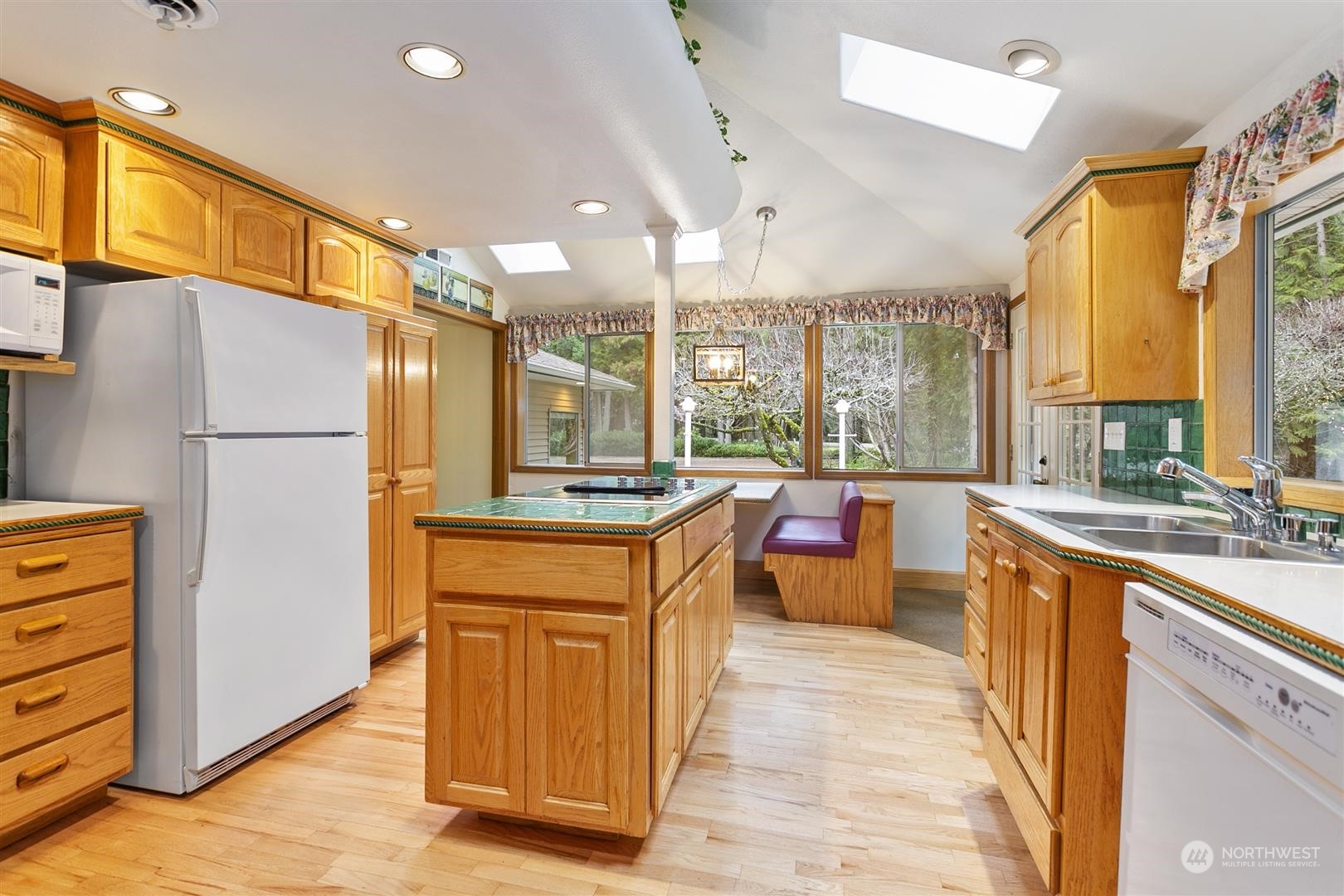 3397 Cedarville Road Bellingham, WA 98226 - Photo 11 of 38 a large kitchen with stainless steel appliances granite countertop a refrigerator a sink dishwasher a stove and a dining table with wooden floor