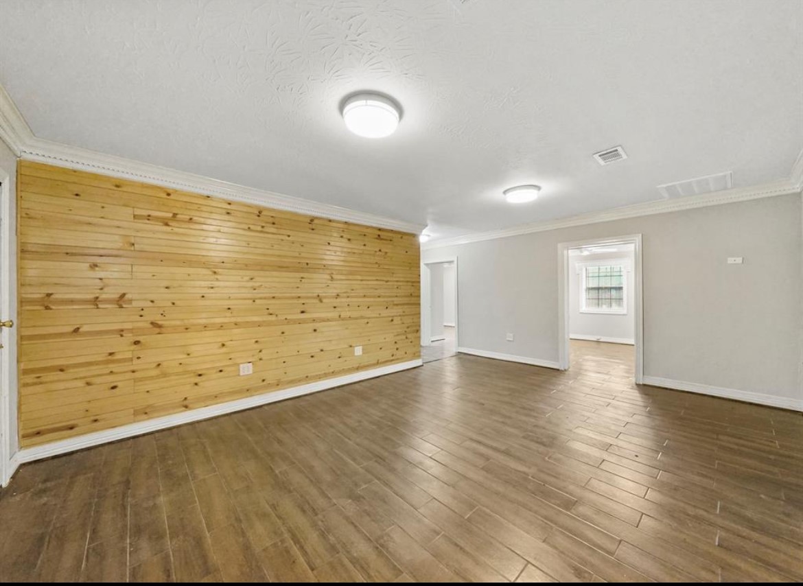 1207 Firnat Street Houston, TX 77022 - Photo 11 of 21 wooden floor in an empty room with a window