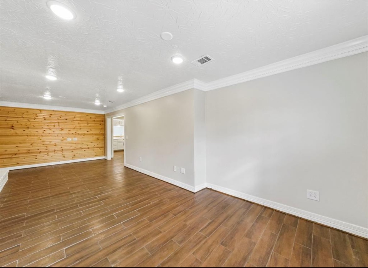 1207 Firnat Street Houston, TX 77022 - Photo 12 of 21 a view of empty room with wooden floor