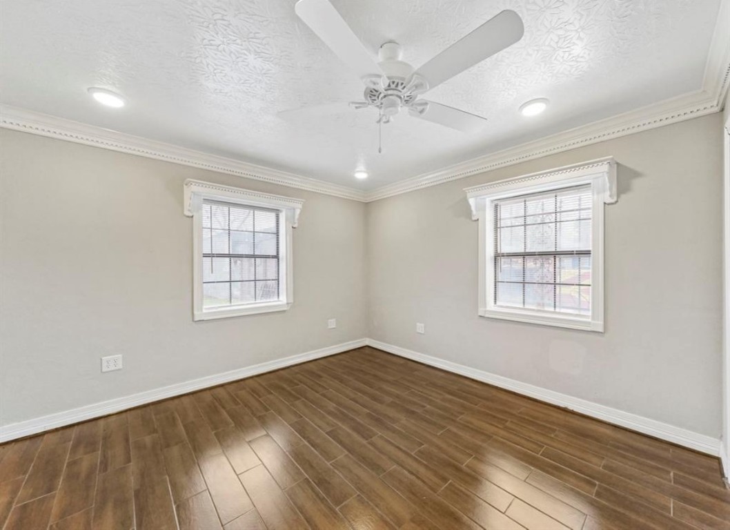 1207 Firnat Street Houston, TX 77022 - Photo 15 of 21 an empty room with wooden floor chandelier fan and windows