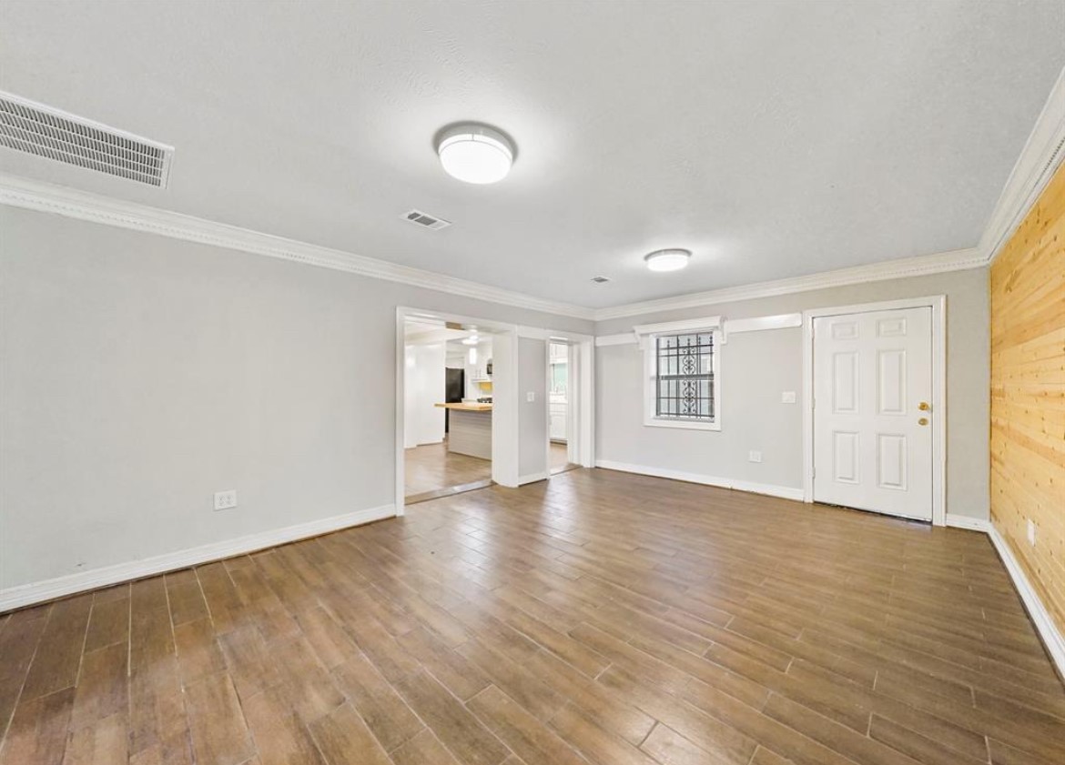 1207 Firnat Street Houston, TX 77022 - Photo 17 of 21 a view of an empty room with wooden floor and a window