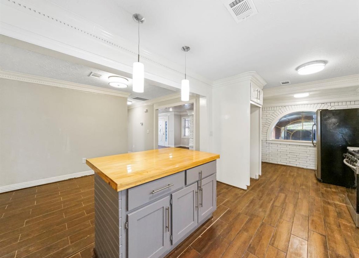 1207 Firnat Street Houston, TX 77022 - Photo 9 of 21 a kitchen with a sink dishwasher and a stove with wooden floor