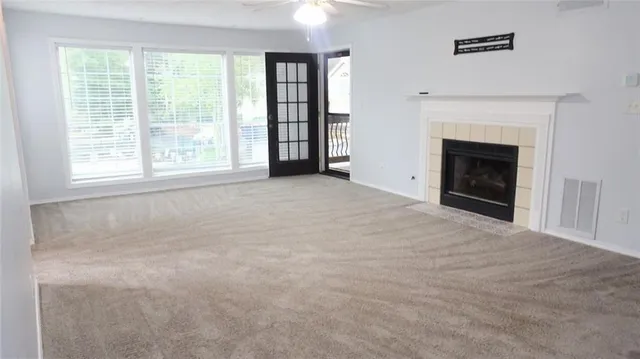 an empty room with windows and a fireplace