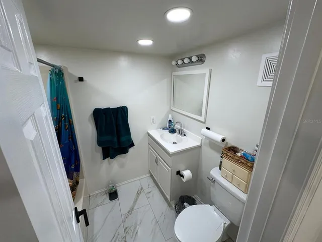 a bathroom with a tub a sink and glass door shower