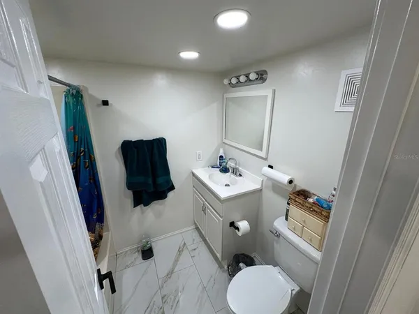 a bathroom with a tub a sink and glass door shower