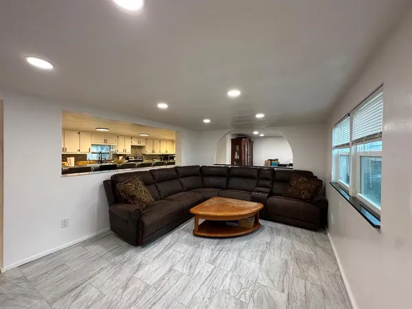 a living room with furniture and a view of kitchen