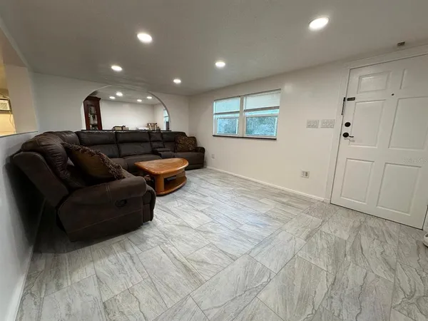 a living room with furniture and a wooden floor