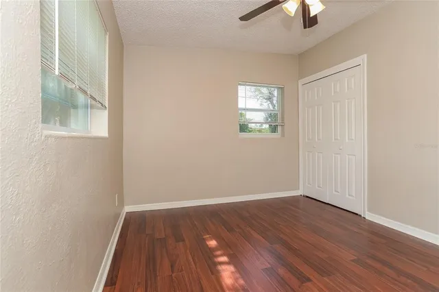 an empty room with a hardwood and ceiling fan