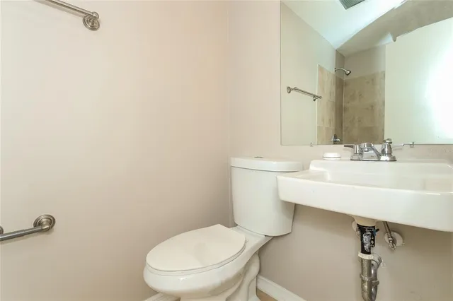 a bathroom with a toilet a sink and mirror