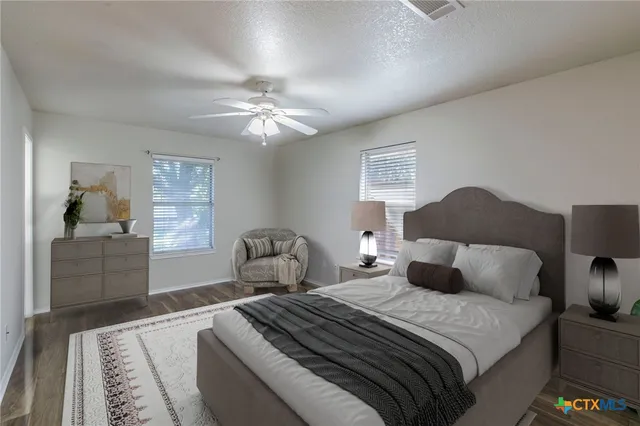 a bedroom with a large bed and a chandelier