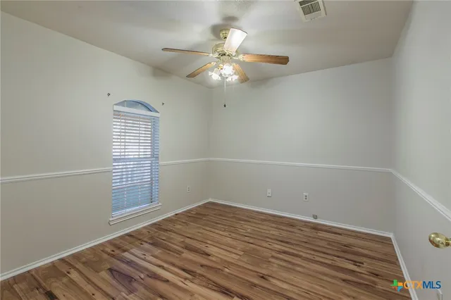 wooden floor in an empty room with a window