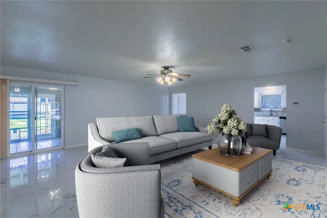 a living room with furniture a chandelier and a window