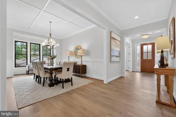 a living room with dining table and a chandelier