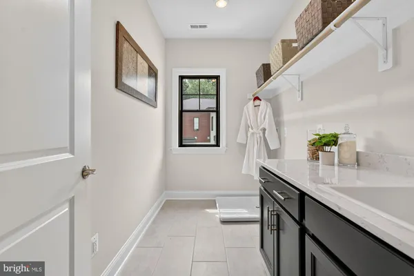 a white house with a small yard and a large tree