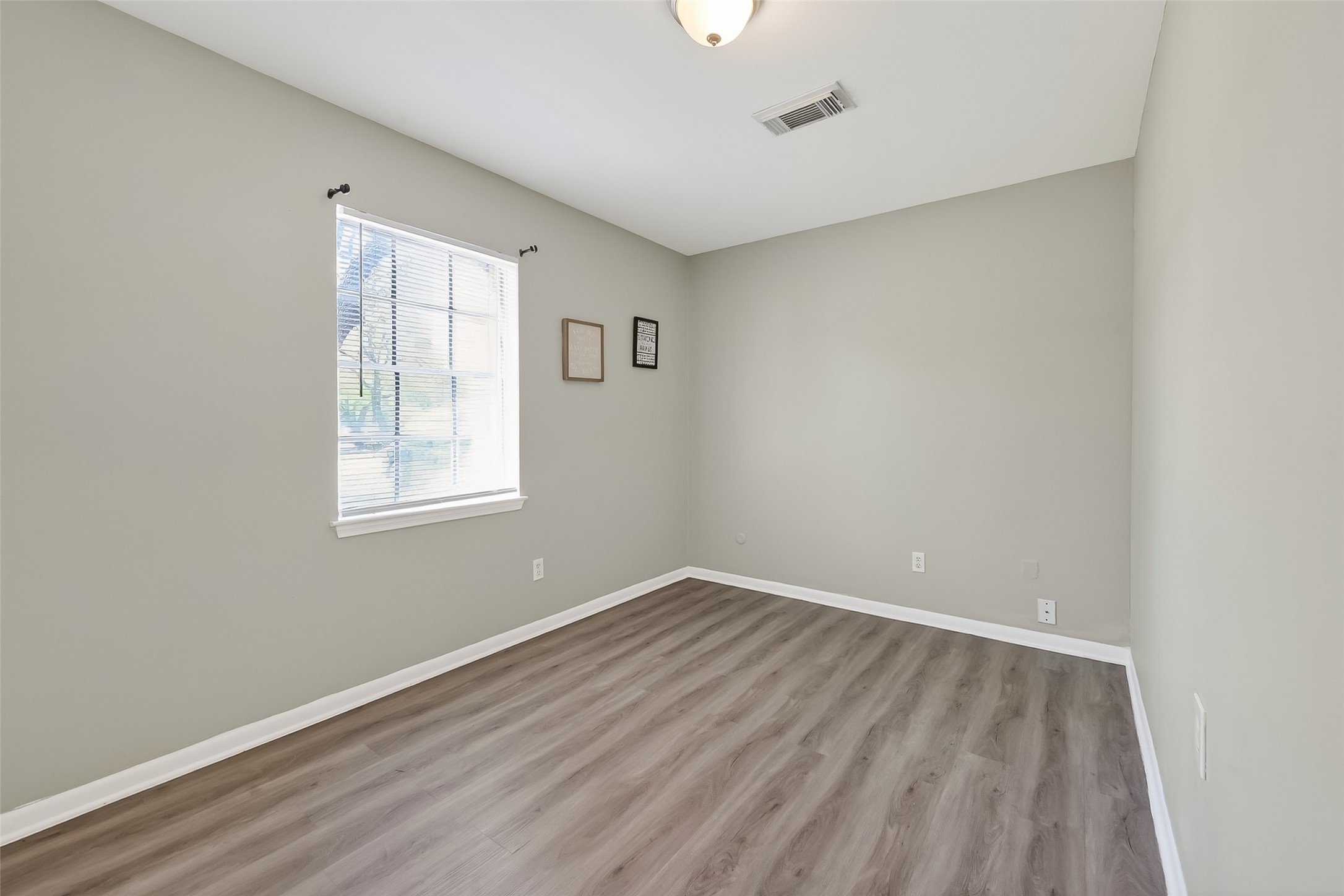 12211 Chimney Rock Road Houston, TX 77035 - Photo 15 of 27 an empty room with wooden floor and windows