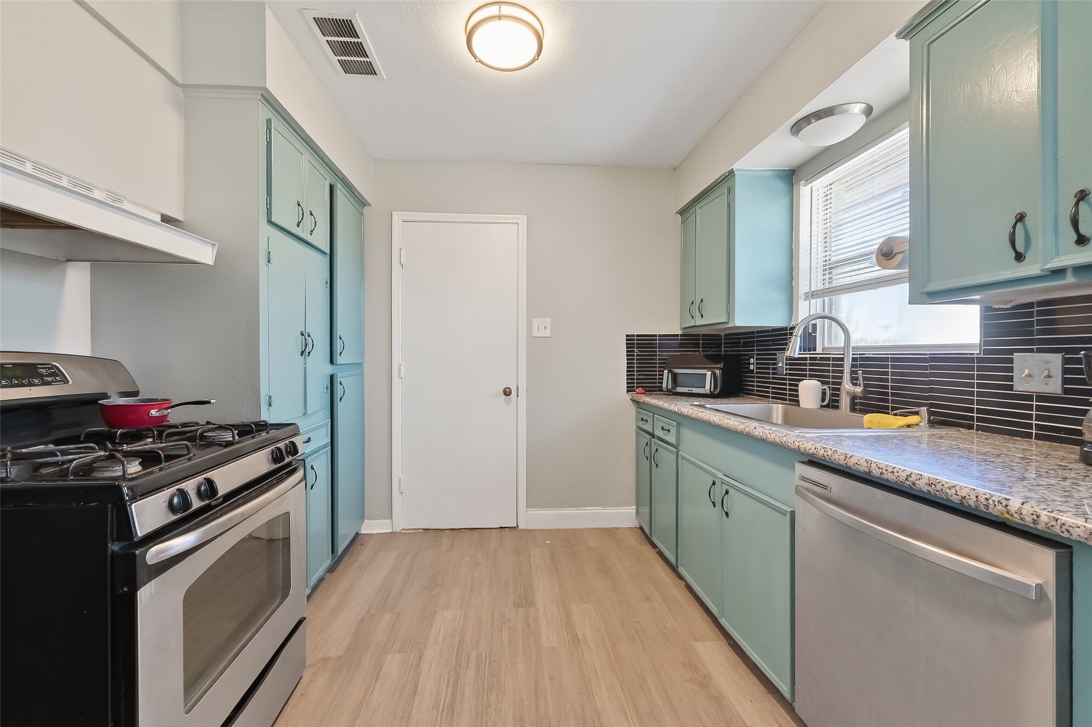 12211 Chimney Rock Road Houston, TX 77035 - Photo 9 of 27 a kitchen with stainless steel appliances granite countertop a sink stove and refrigerator