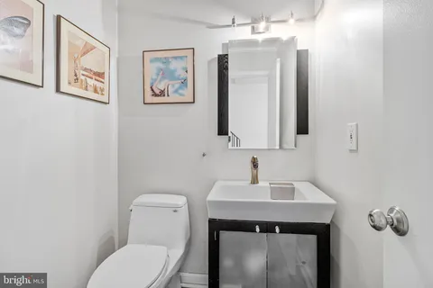 a bathroom with a toilet a sink and mirror