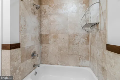 a spacious bedroom with a bed and a flat screen tv