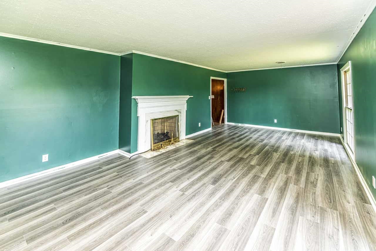 725 Old Brownsville Road Ripley, TN 38063 - Photo 27 of 40 a view of empty room with wooden floor and fireplace