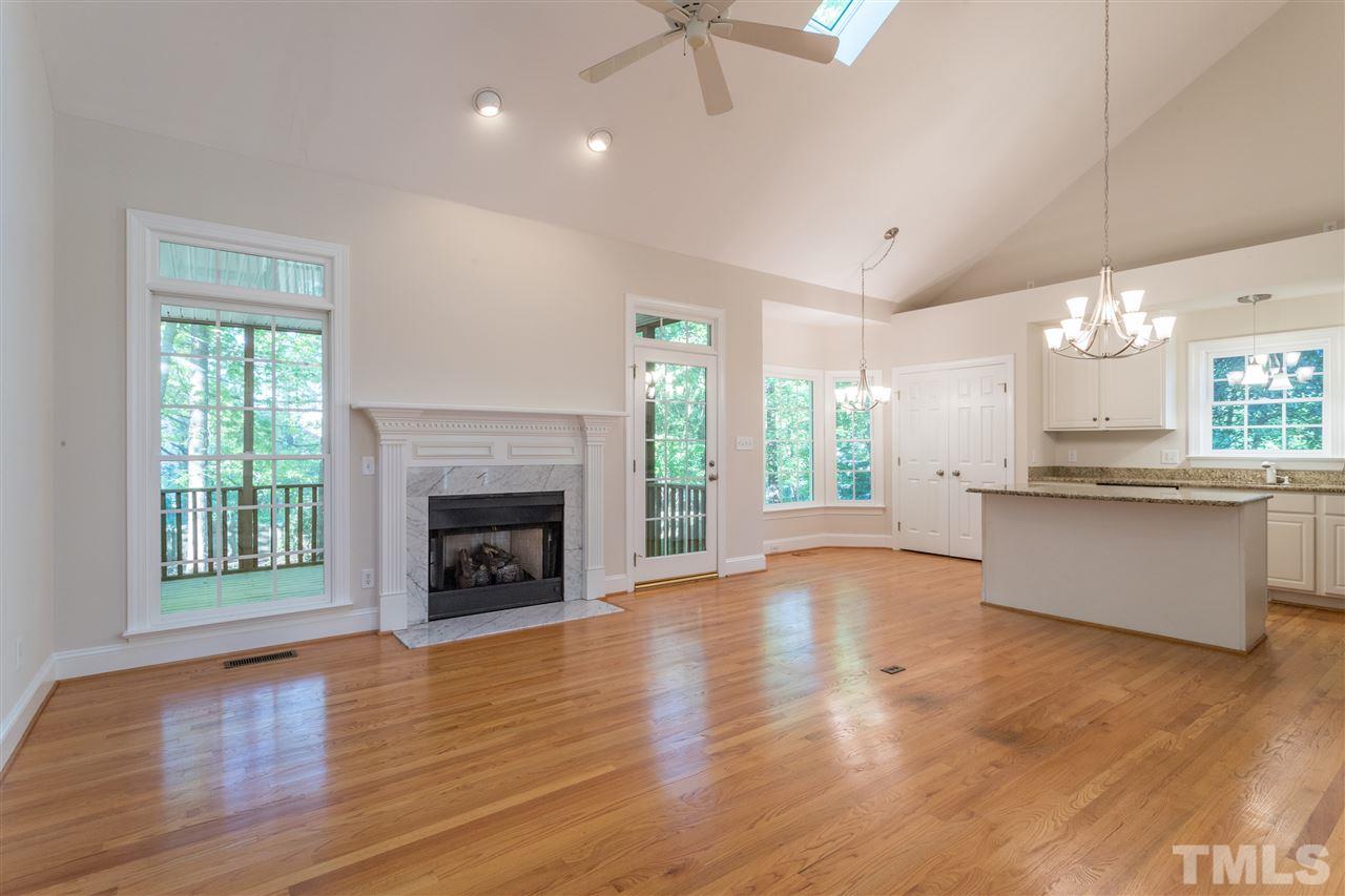3305 Glade Spring Court Raleigh, NC 27612 - Photo 12 of 20 a view of kitchen and hall with wooden floor and a fireplace