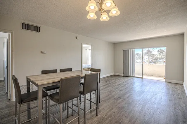 a view of a dining room with furniture a chandelier and wooden floor