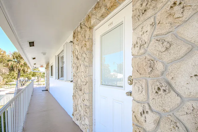 a view of a hallway with wooden floor and windows