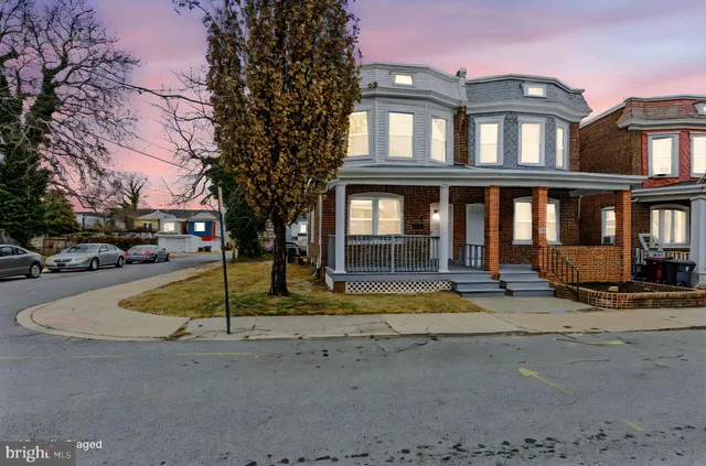 a view of a building with car parked on the road