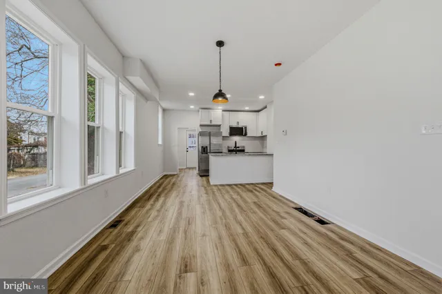 a view of a kitchen with wooden floor and stainless steel appliances