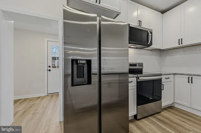 a kitchen with stainless steel appliances kitchen island granite countertop a refrigerator and a stove top oven