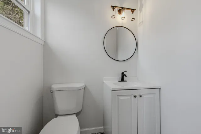 a bathroom with a toilet a sink and a mirror