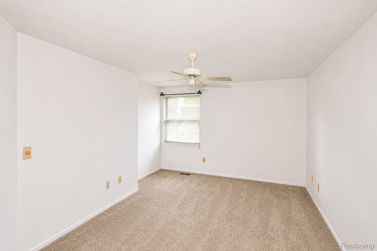 4365 South Crooks Road Royal Oak, MI 48073 - Photo 17 of 25 Room featuring neutral-toned carpeting, white walls, and a ceiling fan