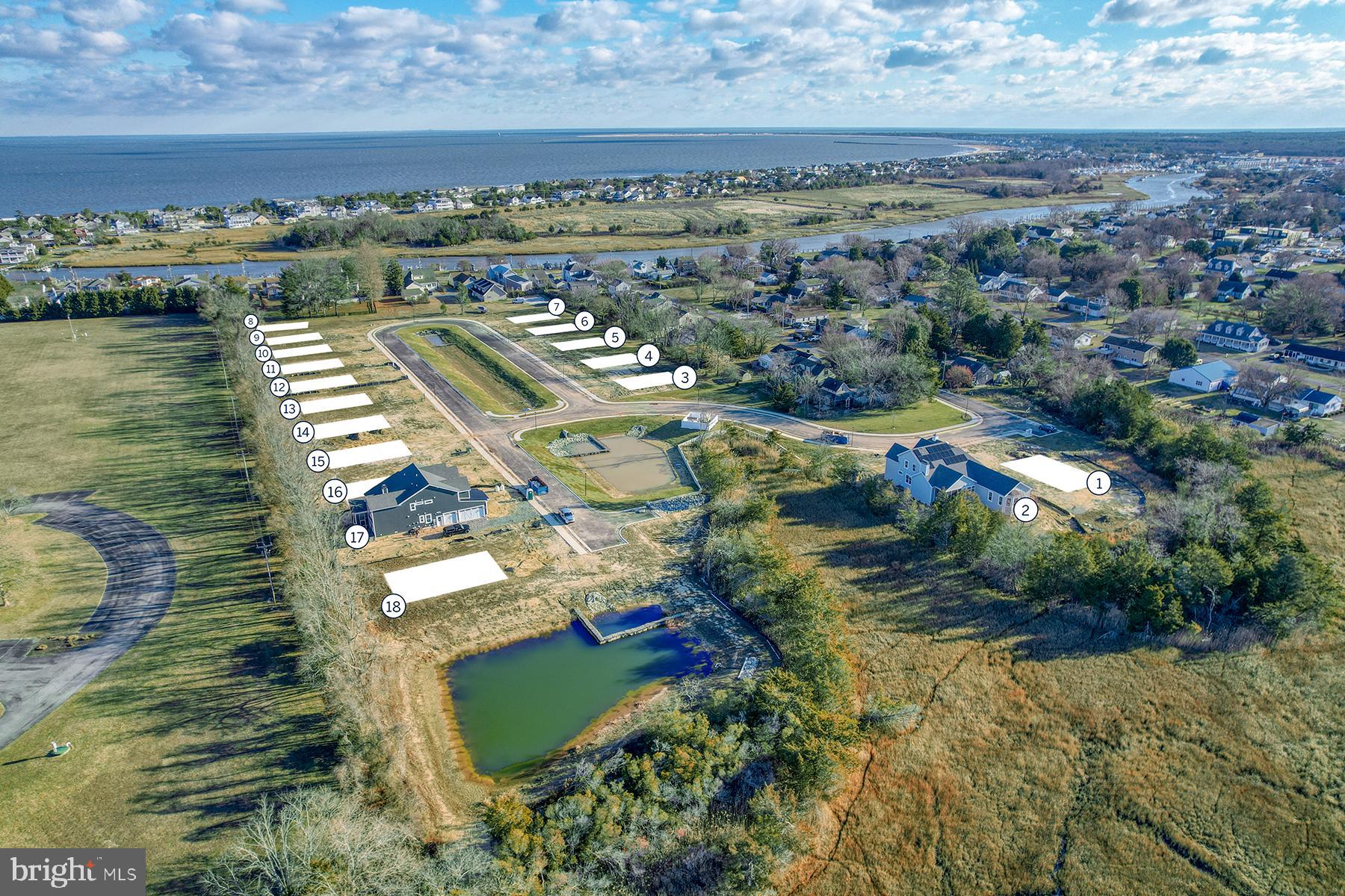 149 Jacks Way, Unit 18 Lewes, DE 19958 - Photo 4 of 26 an aerial view of a city with lots of residential buildings ocean and mountain view in back