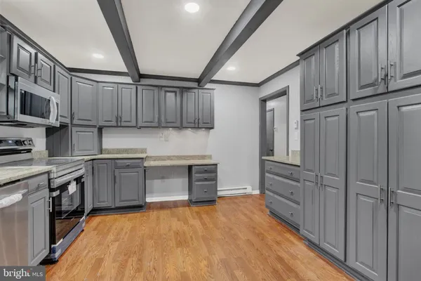 a kitchen with stainless steel appliances granite countertop a refrigerator oven a sink dishwasher and wooden cabinets with wooden floor